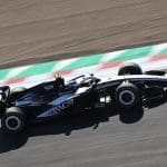 Suzuka'da Cadillac Aston Martin'i geride bırakırken çekilen bir yarış arabası fotoğrafı.