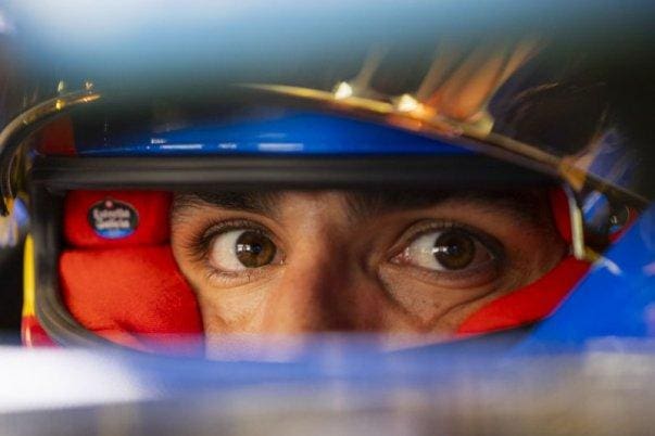 F1 pilotunun kaskı ve pist manzarası, sürüş görüşü konseptini vurguluyor