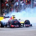 F1 araçlarının yarış pistindeki görüntüsü, V8 motorlu araçlar vurgulanarak.