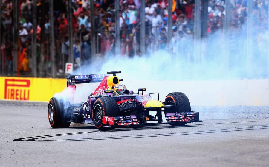 F1 araçlarının yarış pistindeki görüntüsü, V8 motorlu araçlar vurgulanarak.