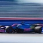 Alpine F1 aracı pistte hızla ilerliyor, sponsor logoları dikkat çekiyor