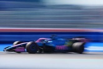 Alpine F1 aracı pistte hızla ilerliyor, sponsor logoları dikkat çekiyor