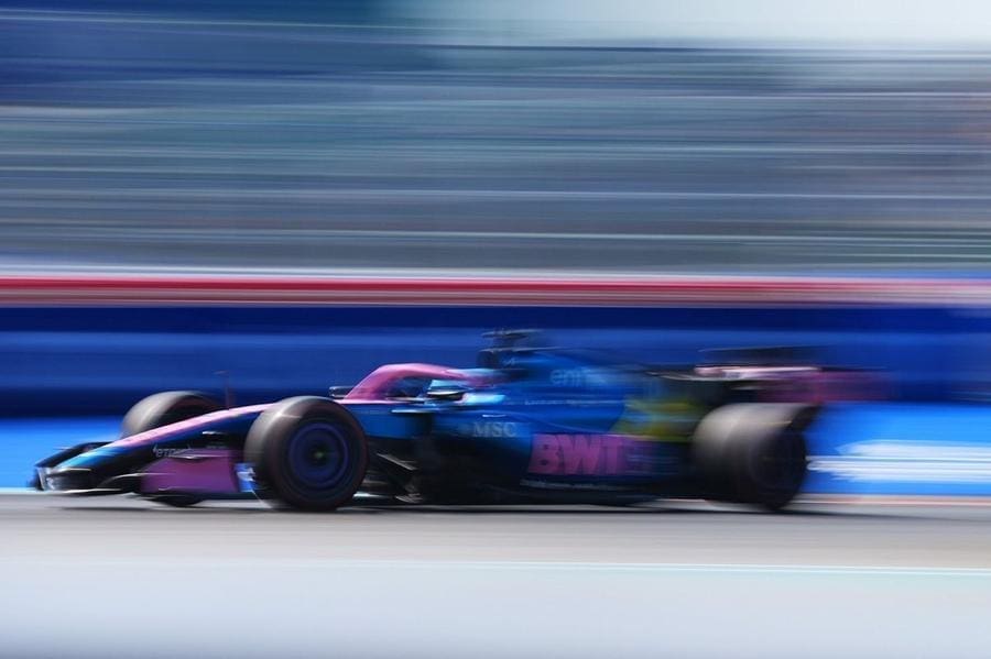 Alpine F1 aracı pistte hızla ilerliyor, sponsor logoları dikkat çekiyor