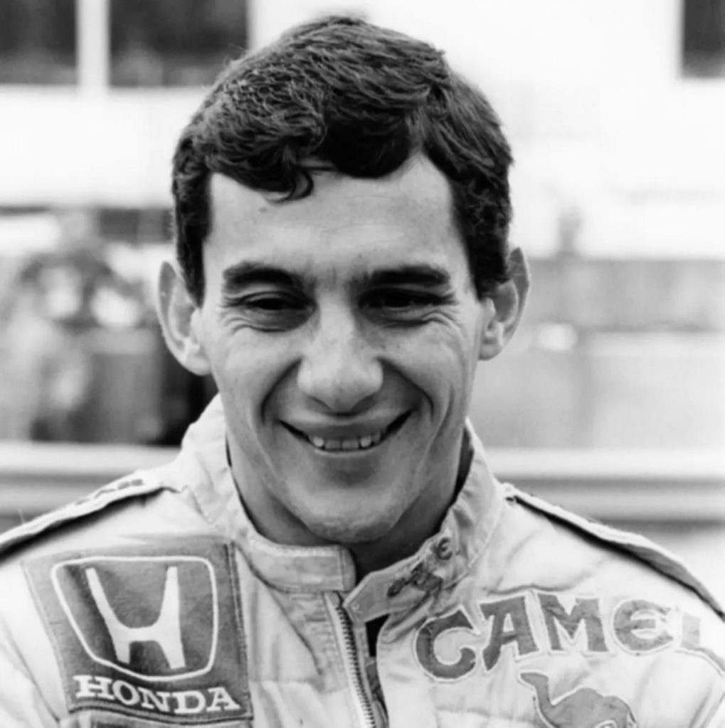 Ayrton Senna siyah beyaz gulumseyen portre Honda Camel Lotus tulumu - 1987 donemi F1 efsanesinin en sevilen fotograflarindan biri