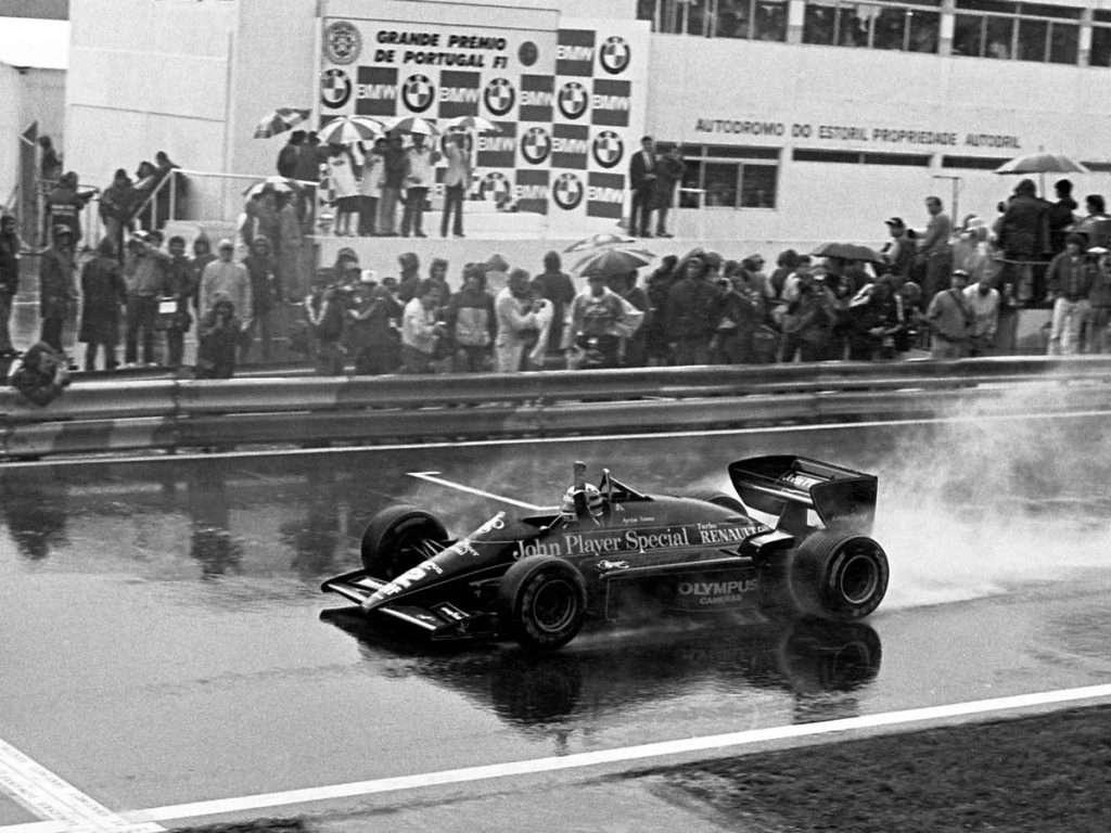 Ayrton Senna Lotus 97T John Player Special ile 1985 Portekiz GP Estoril yagmurunda bitis cizgisini gecerken - F1 kariyerinin ilk zaferi Renault Turbo Olympus Cameras