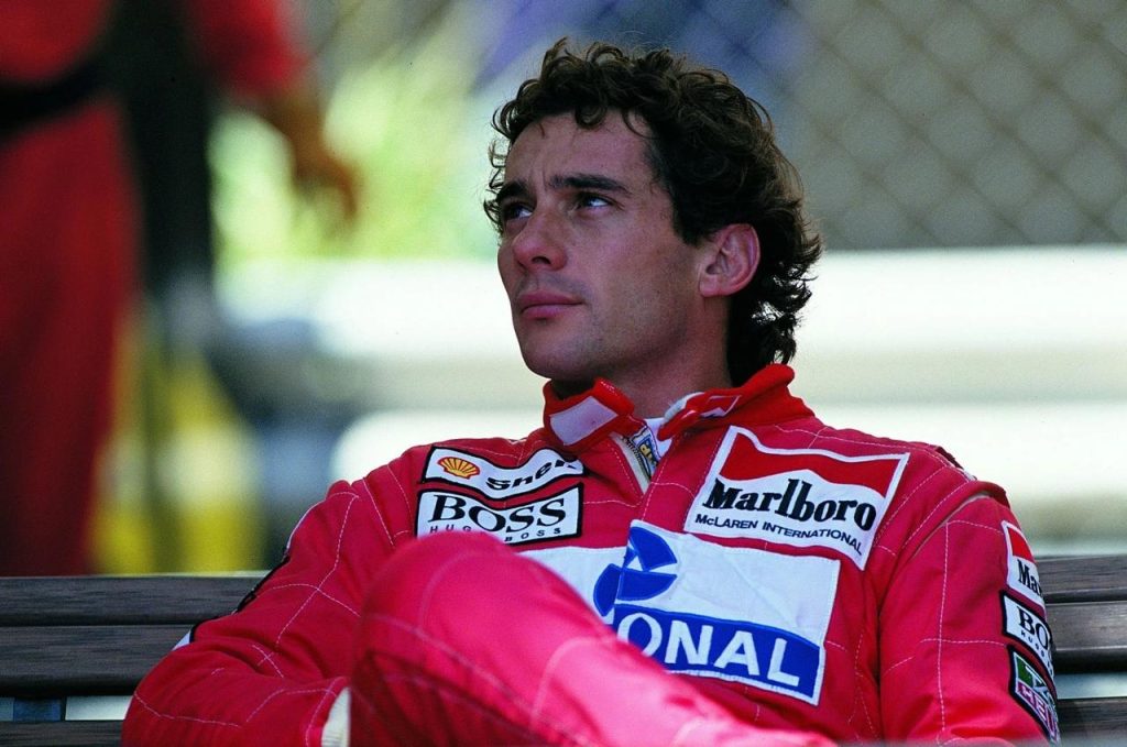 Ayrton Senna Marlboro McLaren tulumunda paddockta derin dusuncelere dalmis — Boss ve Shell sponsorlu kiyafet