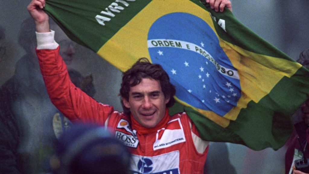 Ayrton Senna McLaren International BOSS Shell tulumunda Brezilya bayragini kaldiriyor - muhtesem zafer gulumsemesi F1 efsanesi