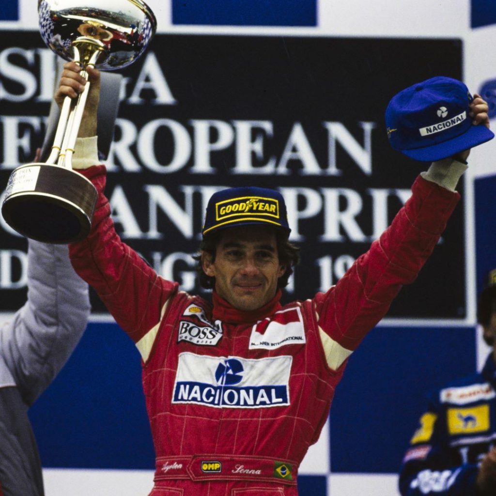 Ayrton Senna Avrupa Grand Prix podyumunda kupay ve Nacional sapkasini kaldiriyor - McLaren International BOSS Goodyear tulum Donington 1993