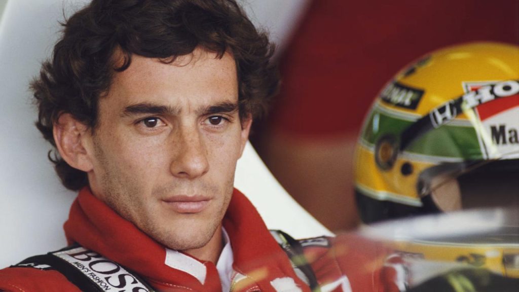 Ayrton Senna McLaren kokpitinde portre — sarı-yeşil kask ve BOSS sponsorlu tulum, 1990 dönemi