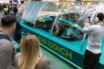 Ziyaretciler Glenfiddich Aston Martin F1 araci telefona cekiyor Kings Cross Londra 2026 Aramco Boss Pirelli cam sise