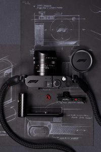 Leica Q3 43 Formula 1 Edition 2026 — karbon fiber sapı, kırmızı düğme detayları ve F1 logosu ile özel limitli seri fotoğraf makinesi