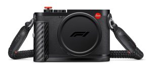 Leica Q3 43 Formula 1 Edition ön görünüm — F1 logolu lens kapağı, karbon fiber kablosuz şarj sapı ve kırmızı deklanşör düğmesi