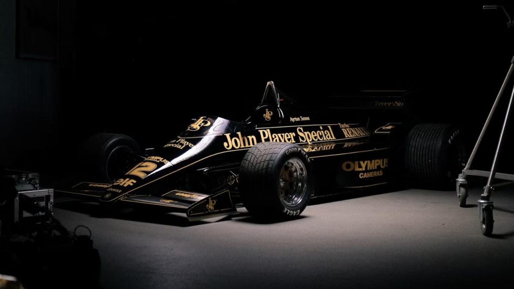 Lotus 97T John Player Special 12 numara Ayrton Senna yazili dramatik studyo cekimi - siyah altin livery Renault Turbo Olympus Cameras Goodyear Eagle 1985